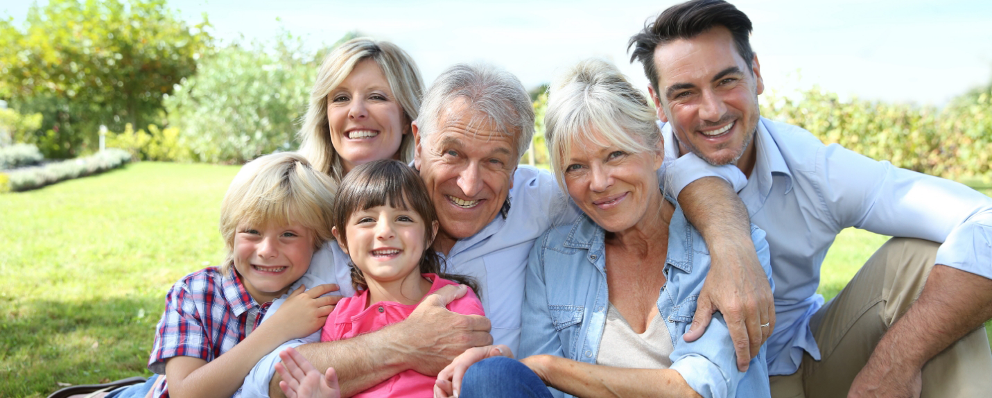 Family sitting together outside and smiling