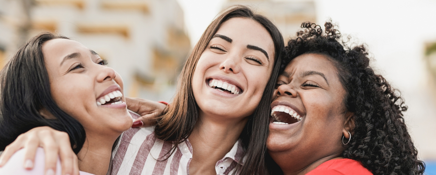 Three woman hugging and laughing together