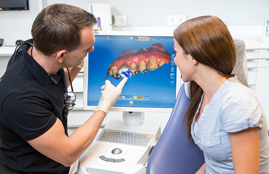 Dentist showing patient impression of teeth on monitor