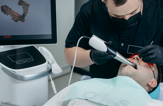 Dentist examining patients teeth with intraoral camera