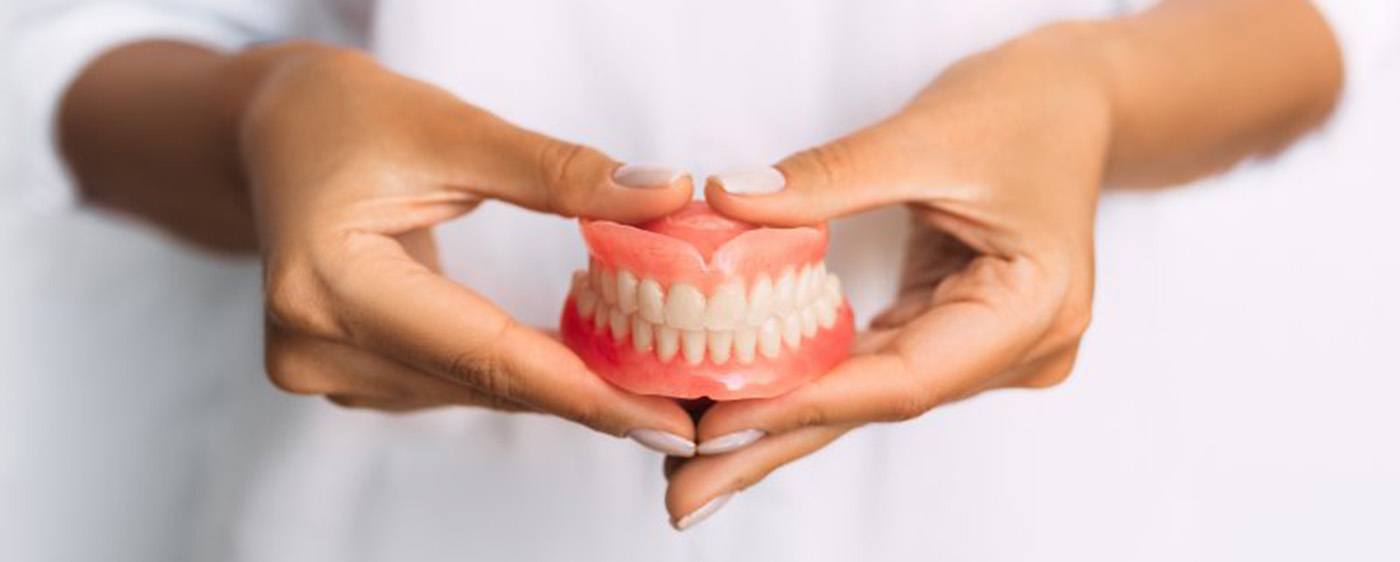 Lady presents viewer with dentures