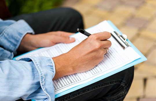Man filling out form on clipboard