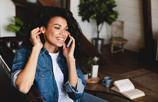 Woman sitting at table and talking on phone