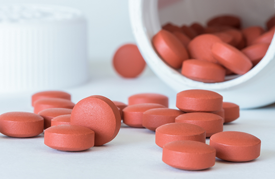 Multiple pills sitting outside of a bottle