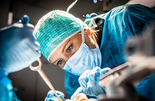 Dentist in surgical mask treating a patient