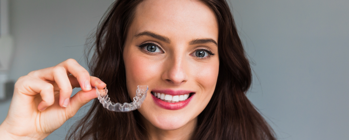 Close up of woman holding Invisalign clear aligner in Montague