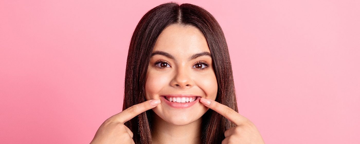 Woman pointing to her smile