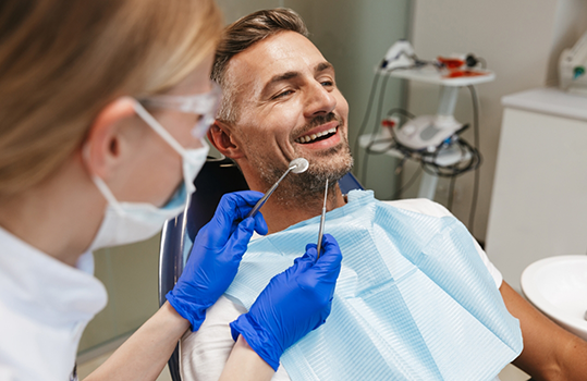 Dental patient in dental chair smiling during treatment