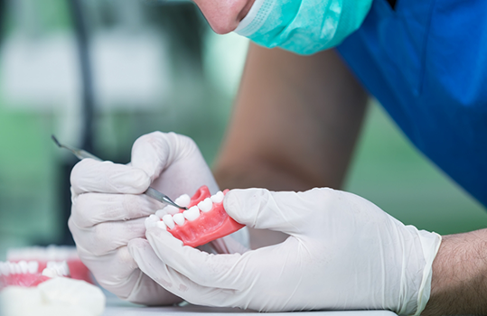 Technician placing teeth into denture