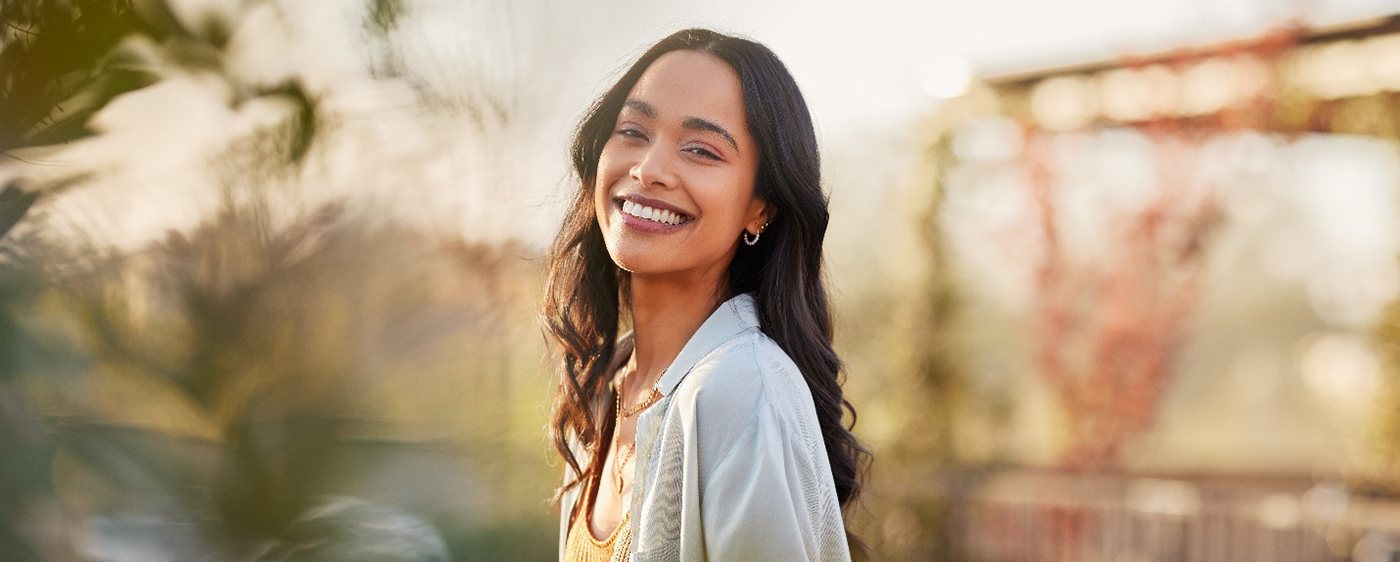 Woman with white teeth smiling outside