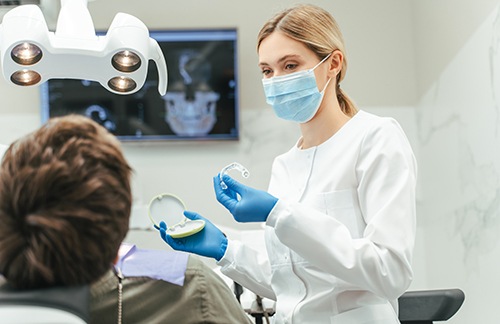 Dentist showing patient whitening tray in treatment room